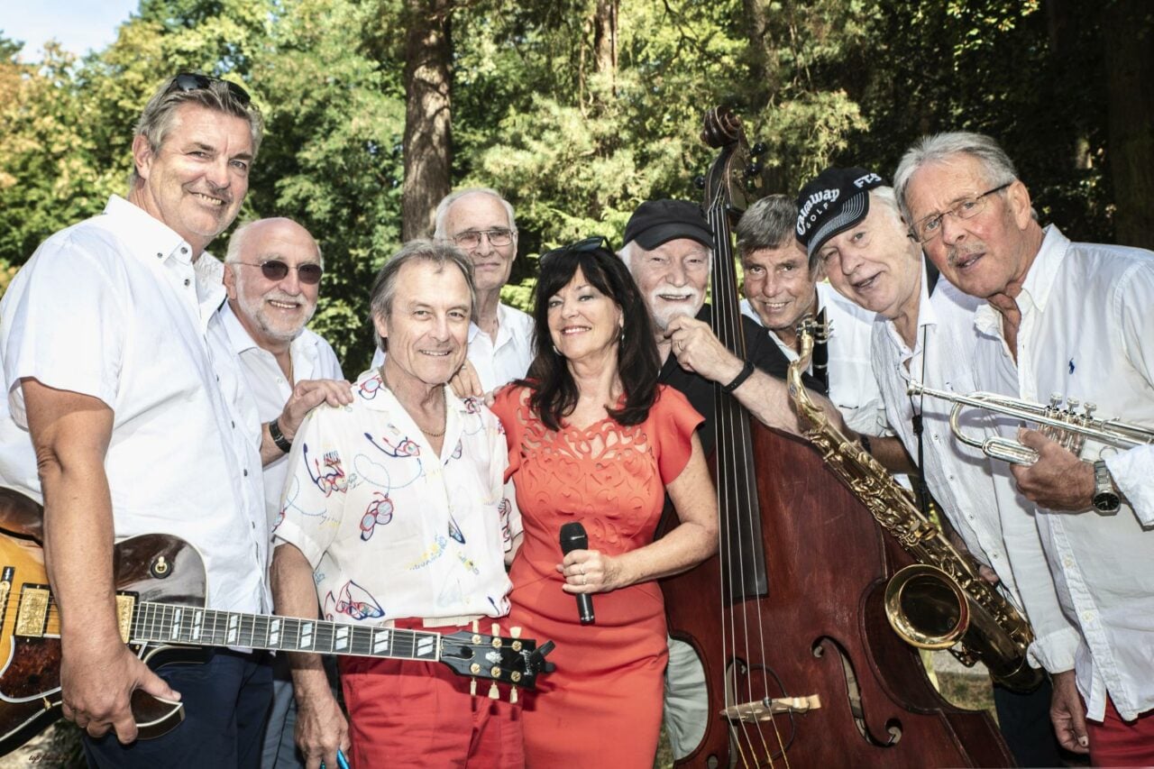 Eine Gruppe von Menschen, die am Wiesenfest teilnehmen und mit ihren Musikinstrumenten für ein Foto posieren.