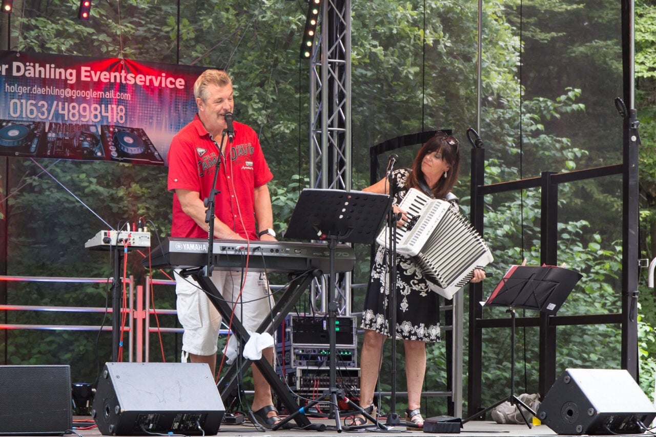 Ein Mann und eine Frau spielen auf der Bühne des Wiesenfestes ein lebhaftes Akkordeon-Duett.