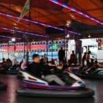 Exciting nighttime bumper car ride at a lively fair illuminated by colorful lights.