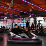 Exciting nighttime bumper car ride at a lively fair illuminated by colorful lights.